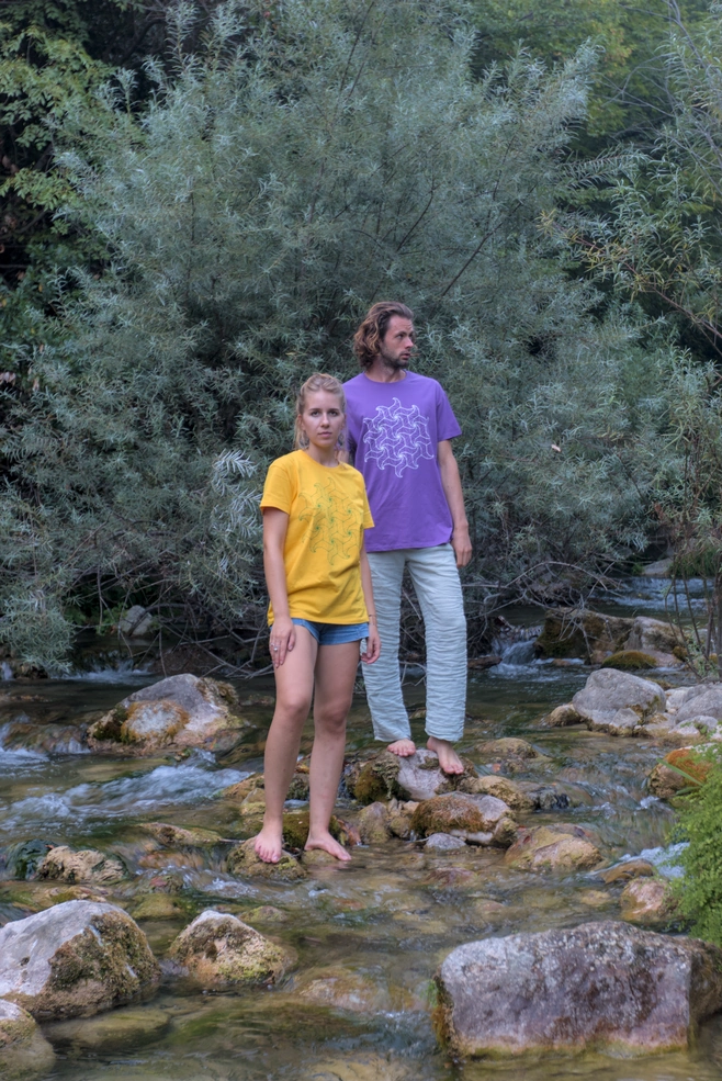 Un homme et une femme portant des T-shirts Spidron debout au milieu d'une rivière