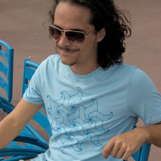 Un homme avec des lunettes de soleil assis sur la Promenade des Anglais portant un T-shirt Spidron